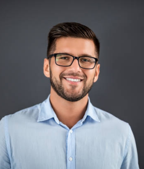 Handsome man standing over dark grey background and looking on camera. Portrait man concept.